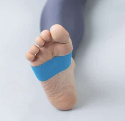 Ein blaues Kinesio-Tape ist auf eine Fußsohle geklebt