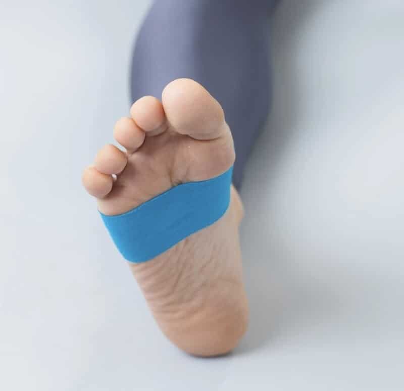 Ein blaues Kinesio-Tape ist auf eine Fußsohle geklebt